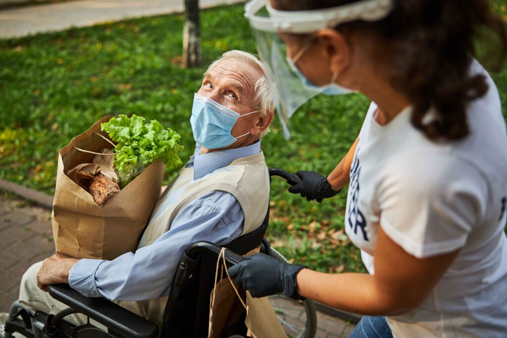 Woman assisting elderly man in wheelchair
